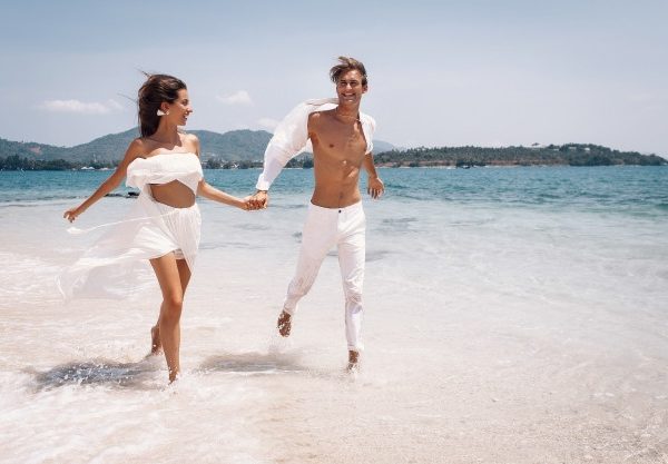 young-beautiful-man-woman-couple-white-clothes-running-along-beach_120960-23