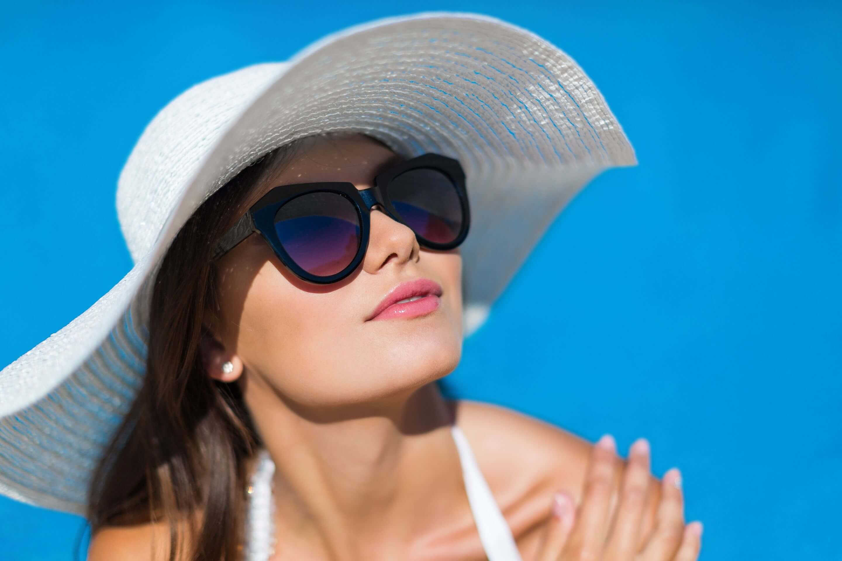 woman wearing sunglasses and hat SU