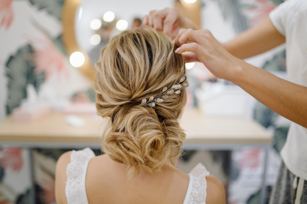 hairdresser-woman-weaving-braid-hair-wedding-styling_1328-2878